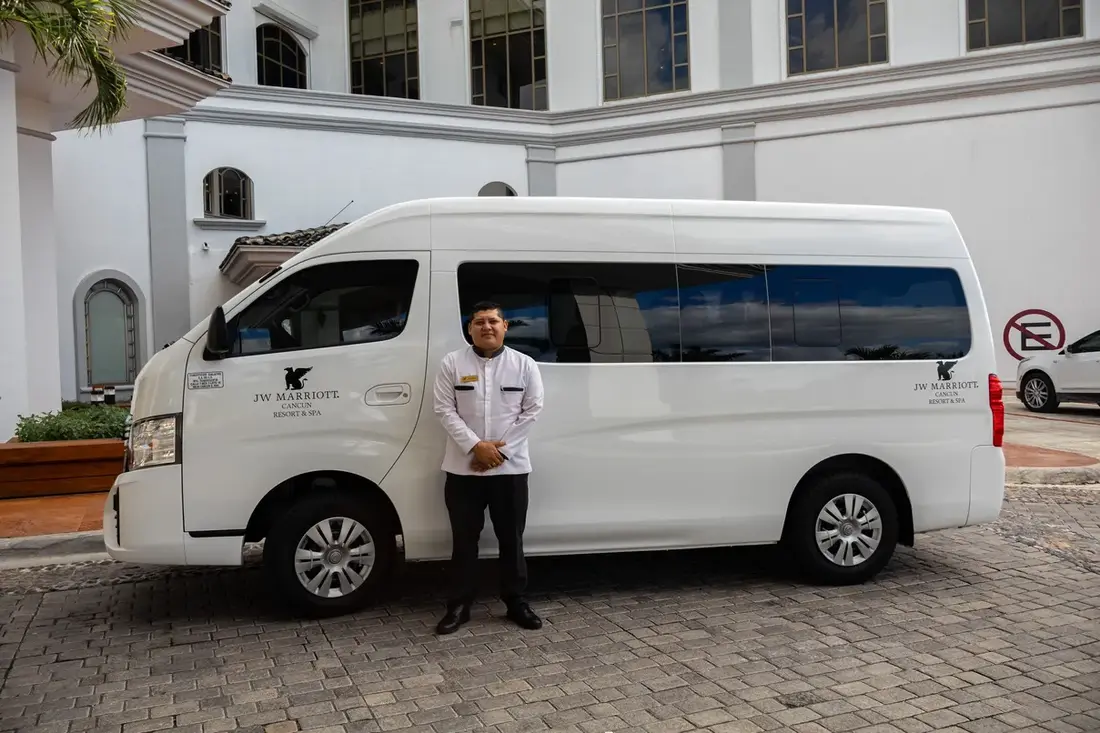 Prestige driver next to a Nissan Urvan at JW Marriott Cancun
